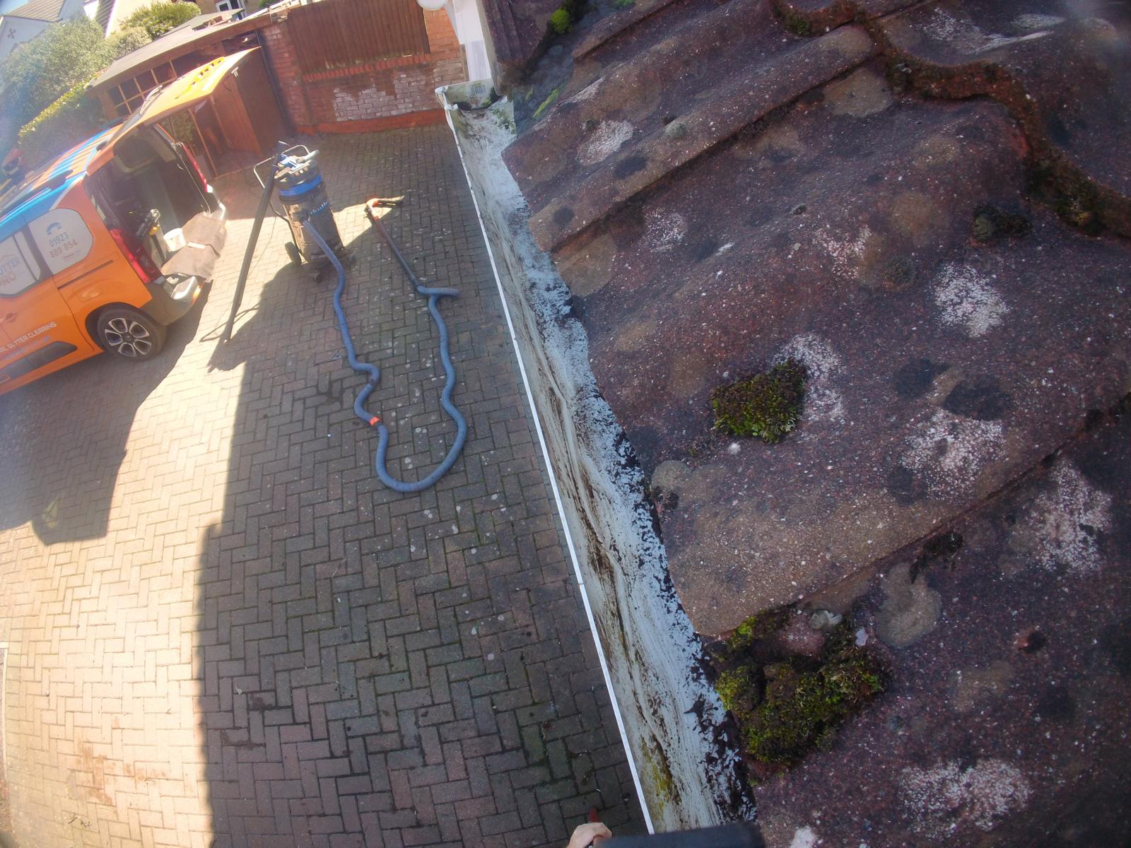 Blocked gutter packed with moss and debris before professional clearing by Gutter Pro