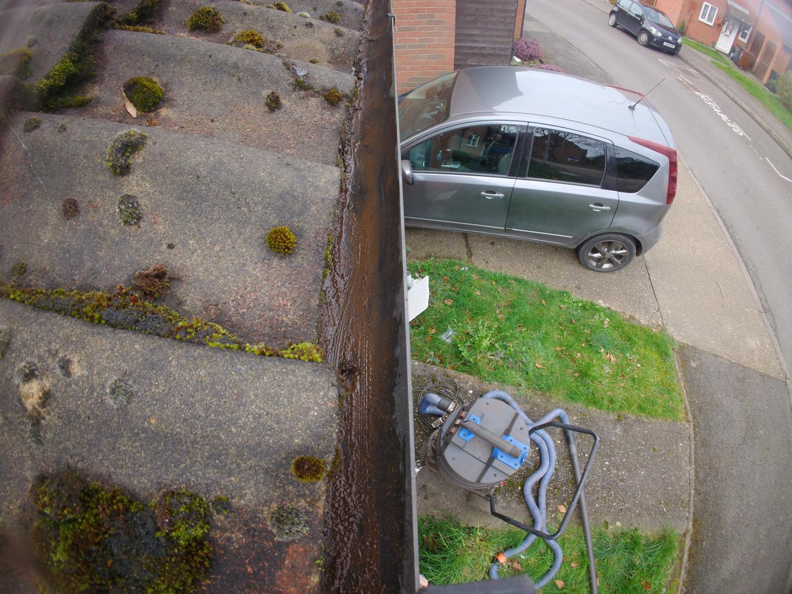 Gutter vacuum equipment positioned on front lawn ready for ground-based gutter clearing on a two-storey property