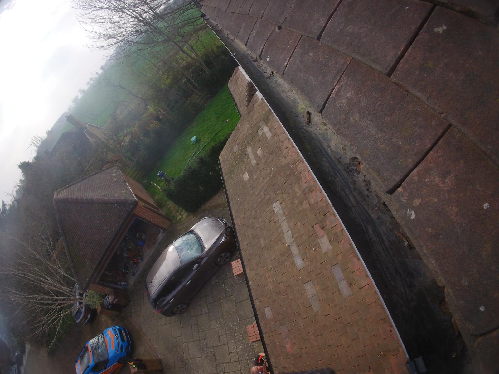 Clean gutter after clearing with Gutter Pro van visible at street level